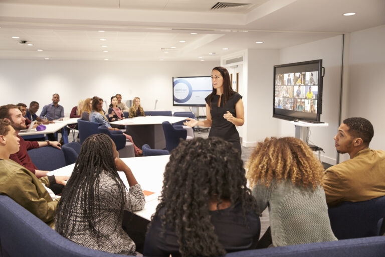 Female teacher addressing university students in a classroom
